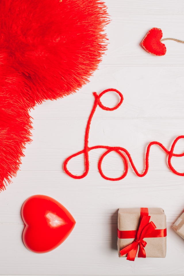 Большая подушка в форме сердца на столе с подарками 