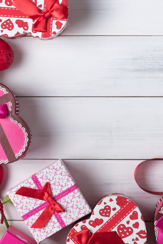 Много подарочных коробок в форме сердца на сером столе 