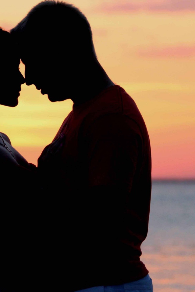 Влюбленная пара на фоне моря в сумерках 