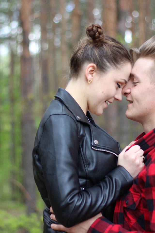 Влюбленная пара стоит в лесу 