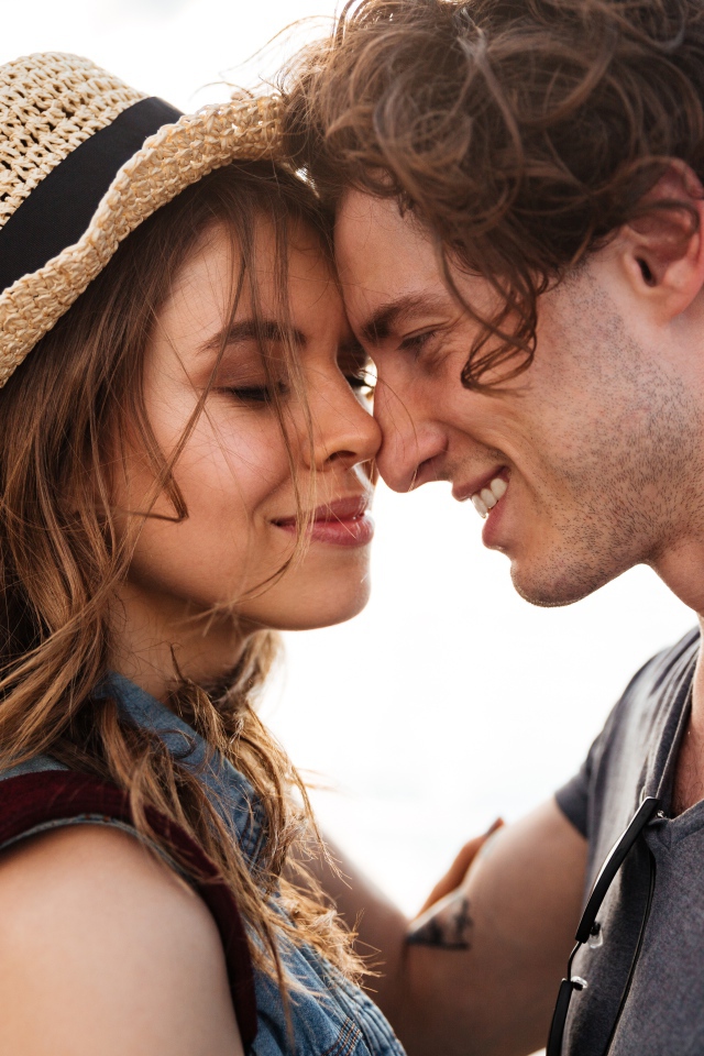 Влюбленная пара стоит на фоне моря 