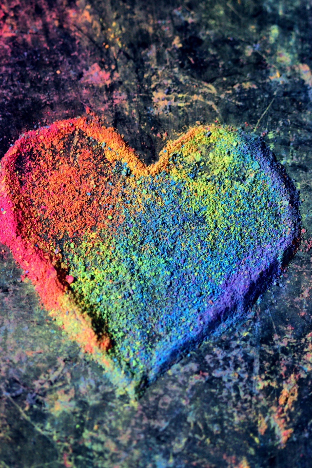 Разноцветное сердце из сухой краски на сером фоне