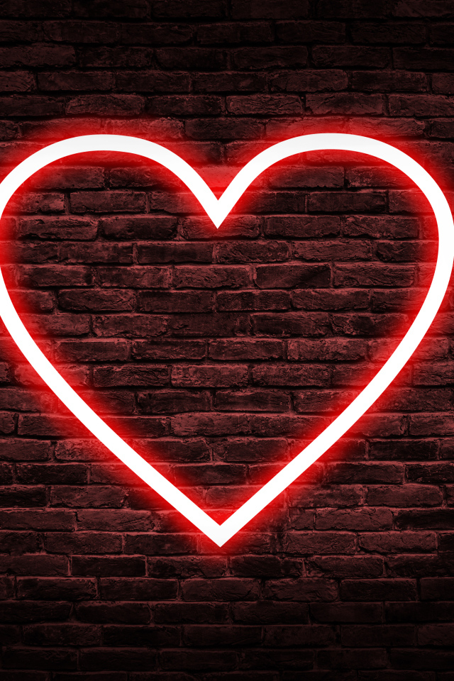 Красное неоновое сердце на кирпичной стене 