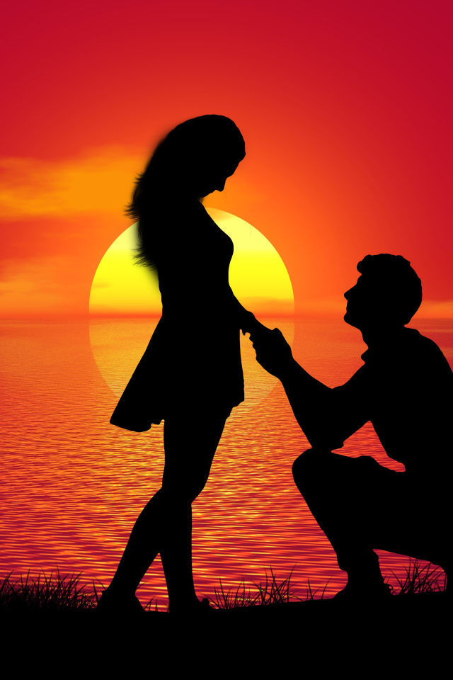 Парень делает девушке предложение на фоне заката у моря