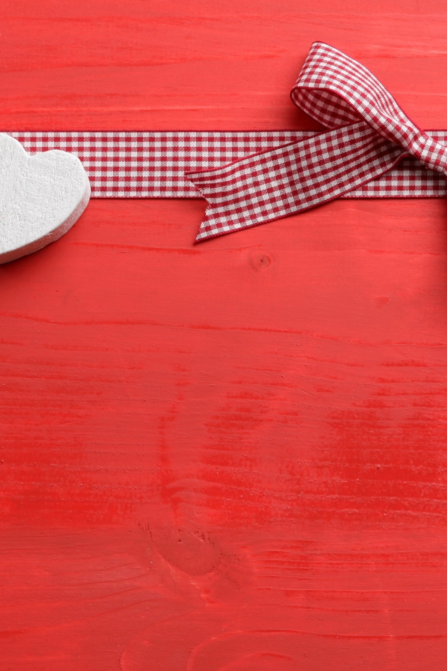 Два сердечка с бантом на красном фоне