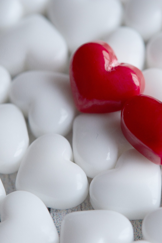 Два красных сердца лежат на белых 
