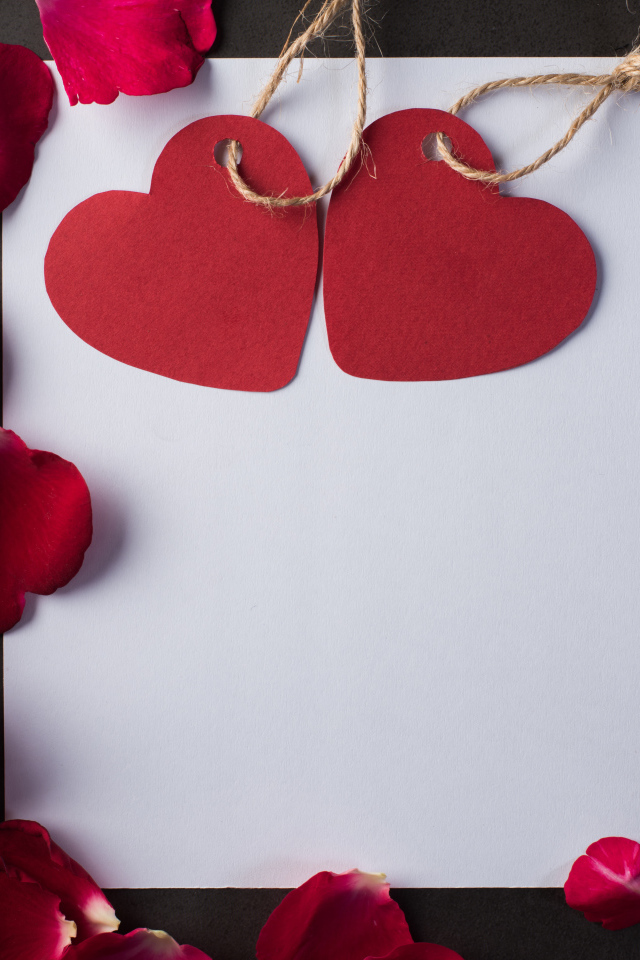Белый лист бумаги с сердечками и лепестками роз 