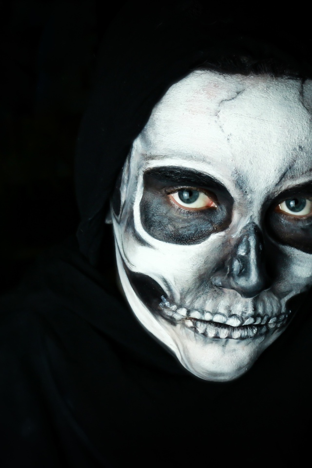 Мужчина в черном наряде с гримом на лице на Хэллоуин