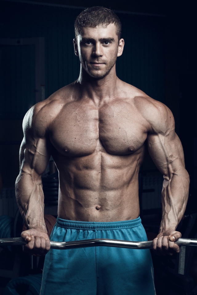 Красивый накаченный мужчина со штангой в руках 