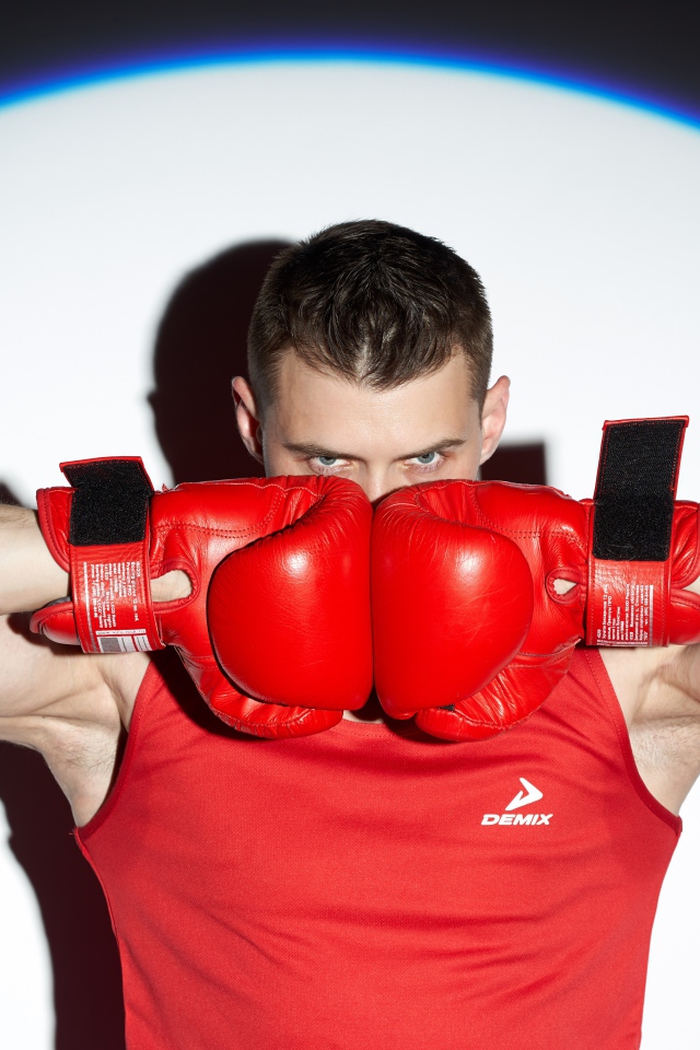 Male boxer with red gloves in the spotlight