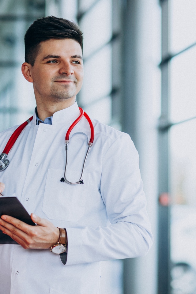 Мужчина доктор в больнице у окна 