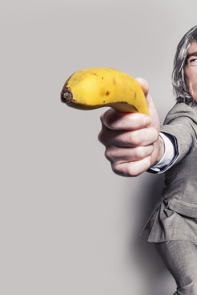 Мужчина в костюме защищается бананом