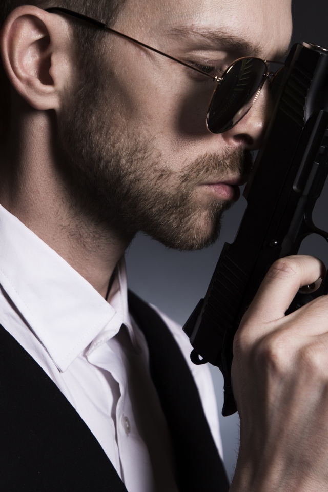Мужчина в очках с пистолетом в руке