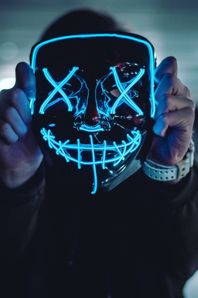 Neon mask anonymous in the hands of a guy