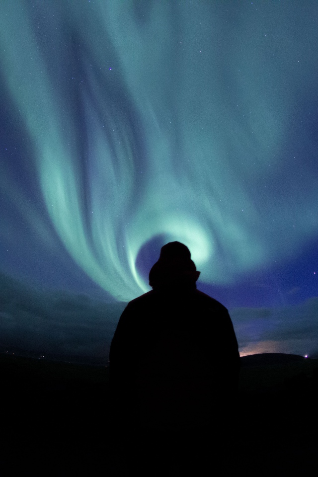 Силуэт мужчины на фоне неба с полярным сиянием