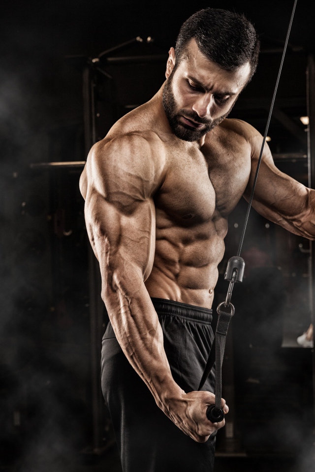 Сильный мужчина бодибилдер в спортзале