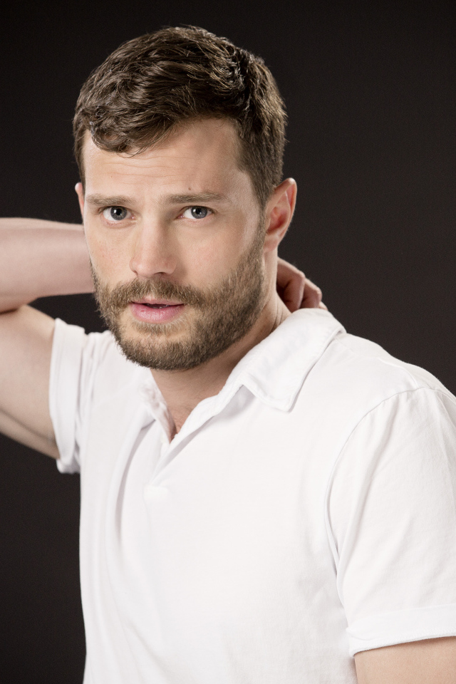 Актер Джейми Дорнан в белой рубашке на коричневом фоне