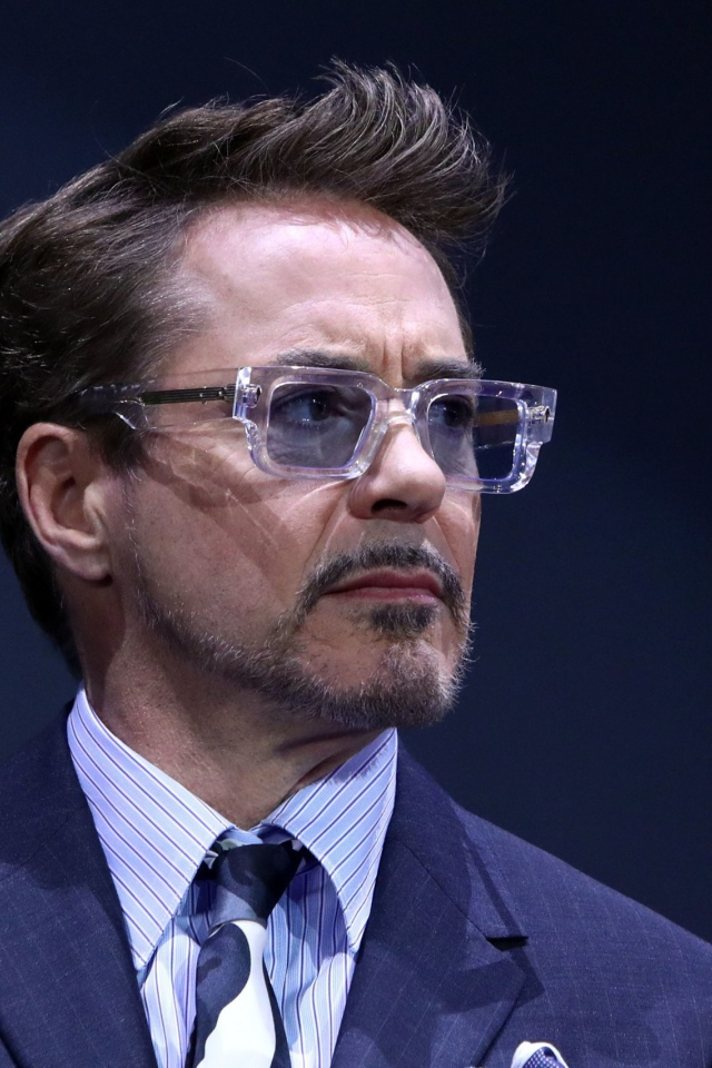 Актер Роберт Дауни-младший в костюме на синем фоне