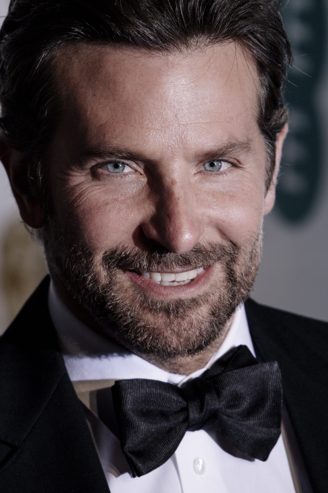 Улыбающийся актер Брэдли Купер в костюме