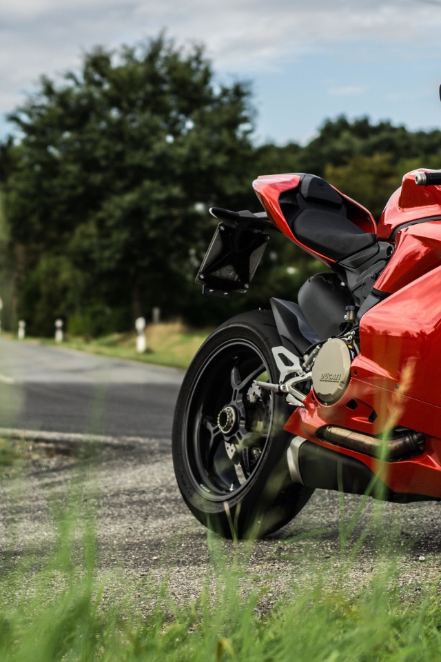 Красны мотоцикл Ducati 1299 Panigale на трассе 