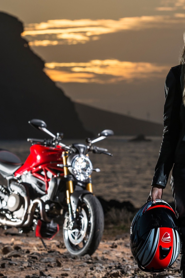 Young blonde woman in leather suit on motorcycle