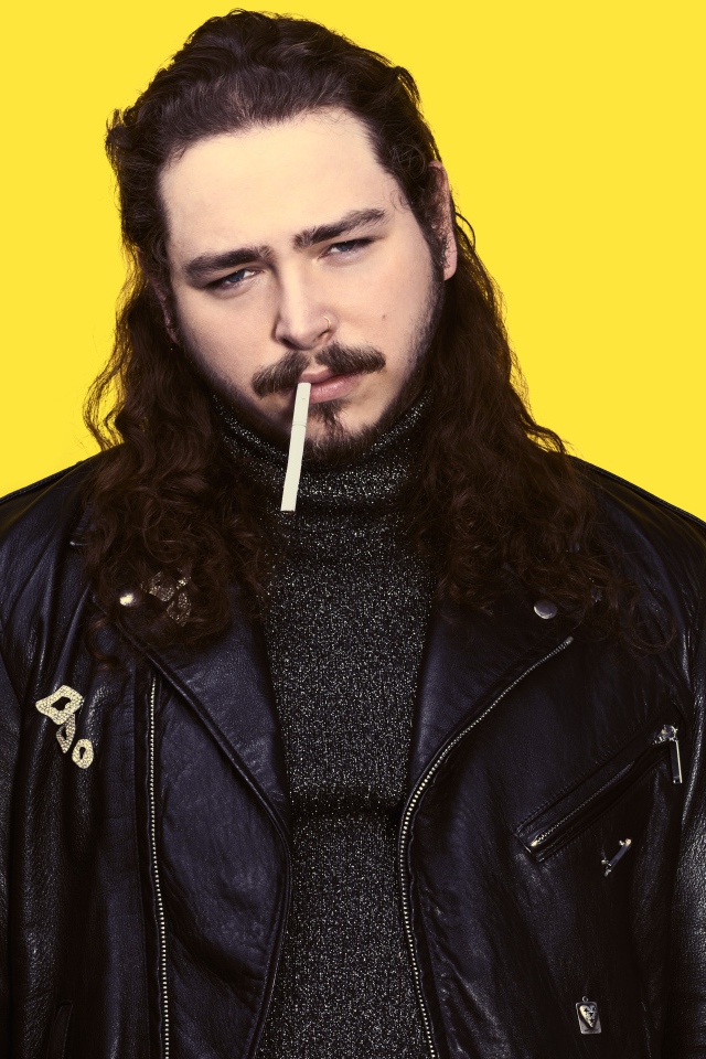 Американский рэпер Post Malone в черной куртке на желтом фоне