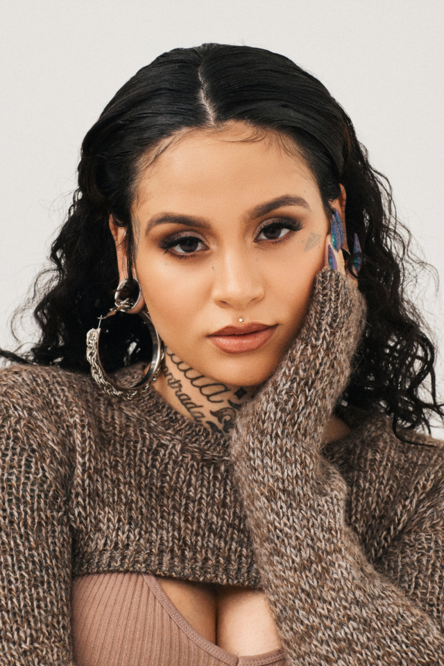 Американская певица Кейлани в свитере на сером фоне