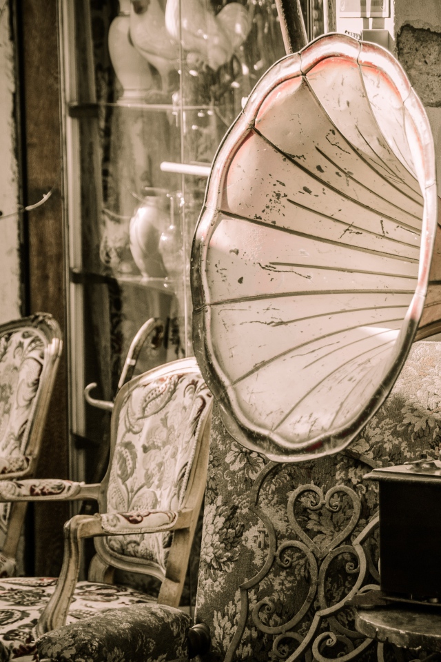 Большой старый граммофон в комнате со стульями