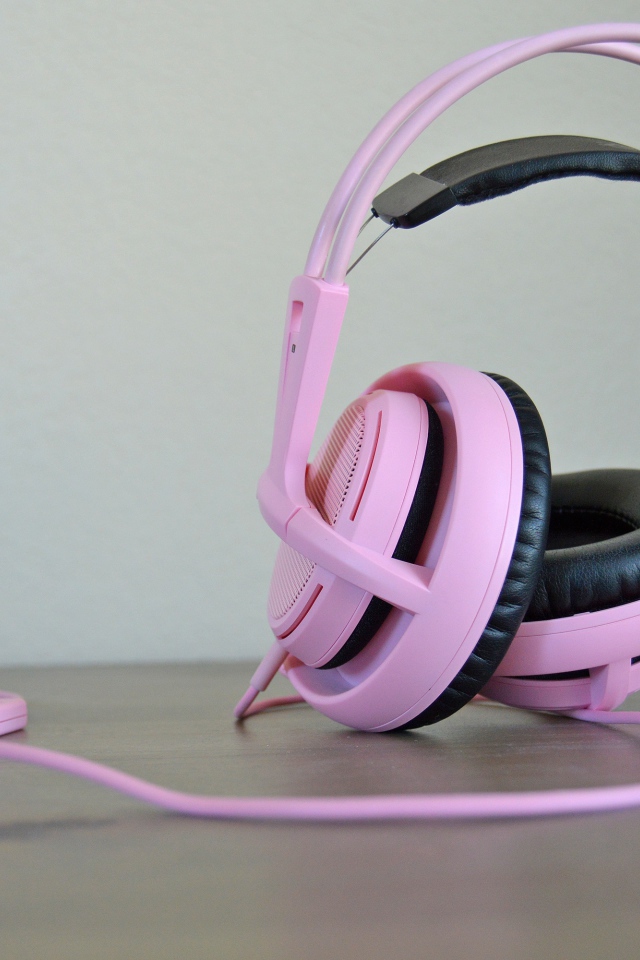 Большие розовые наушники на столе 