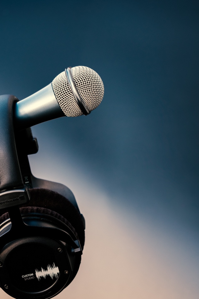 Микрофон с черными наушниками на стойке 