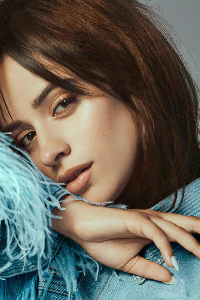 Певица Камила Кабельо в джинсовой куртке на сером фоне