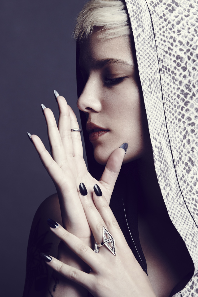 Певица Холзи в капюшоне на сером фоне