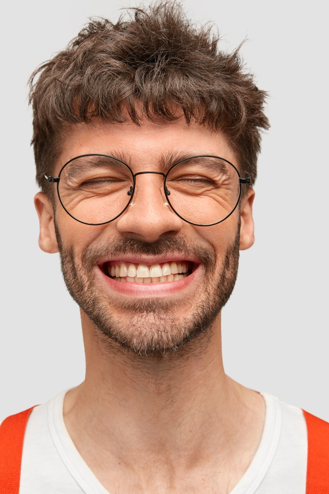 Улыбающийся бородатый мужчина в очках 