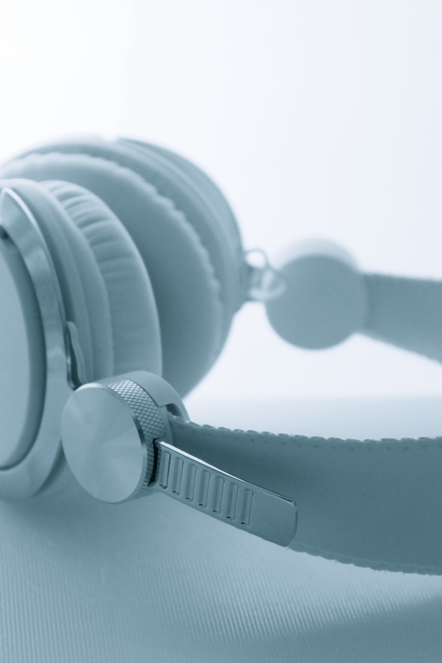 Белые большие наушники лежат на белом фоне