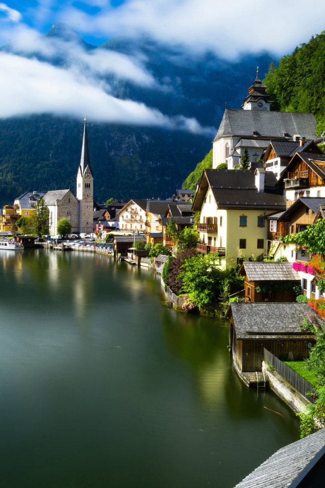 Красивые дома на берегу спокойного озера у подножия гор 