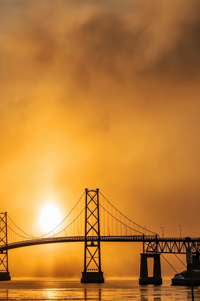 Мост через реку в тумане на восходе солнца