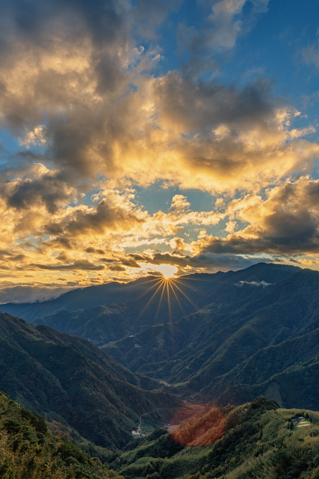 Рассвет солнца в облачном небе над горами 