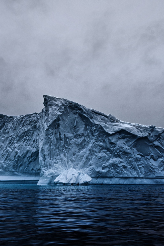 Большой айсберг в океане под пасмурным небом