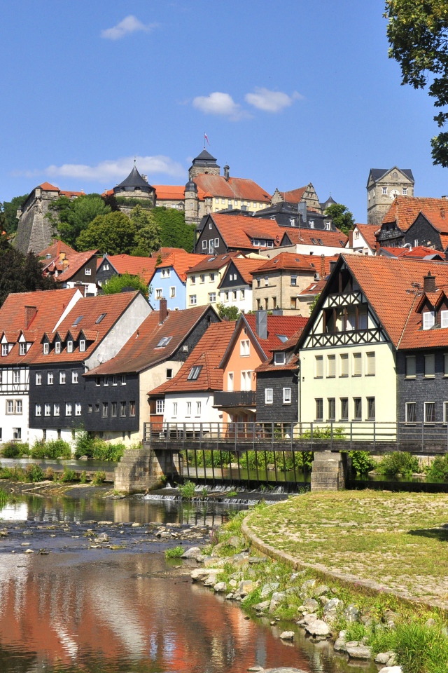 Много домов у пруда на фоне голубого неба