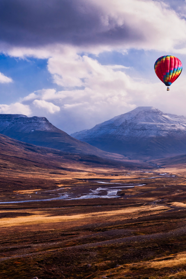 Разноцветный воздушный шар в небе над горами