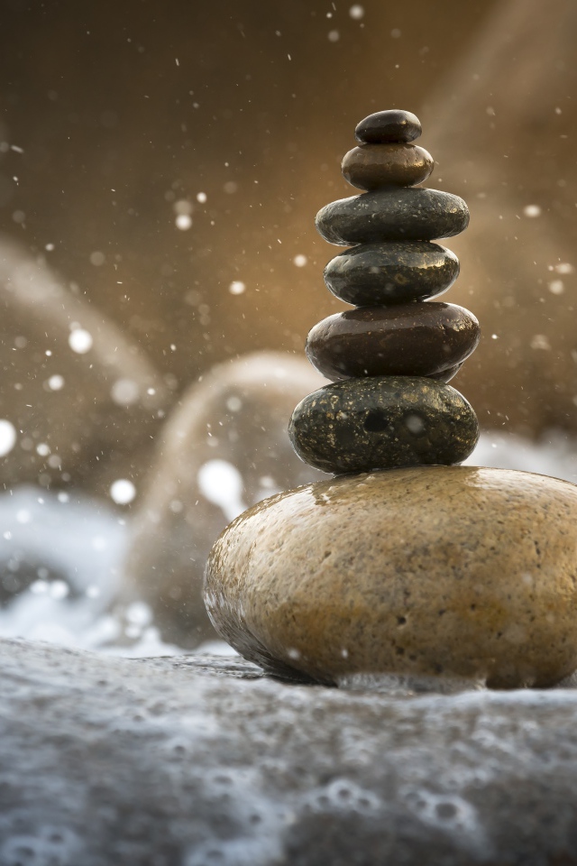 Гладкие мокрые камни в белой морской пене 