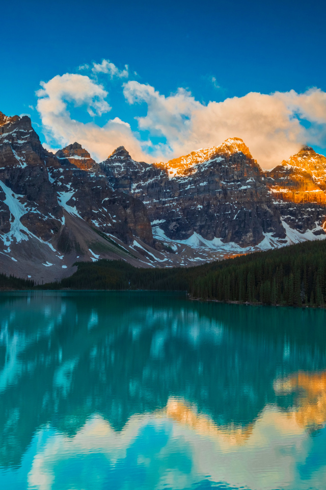 Солнце над высокими горами у голубого озера