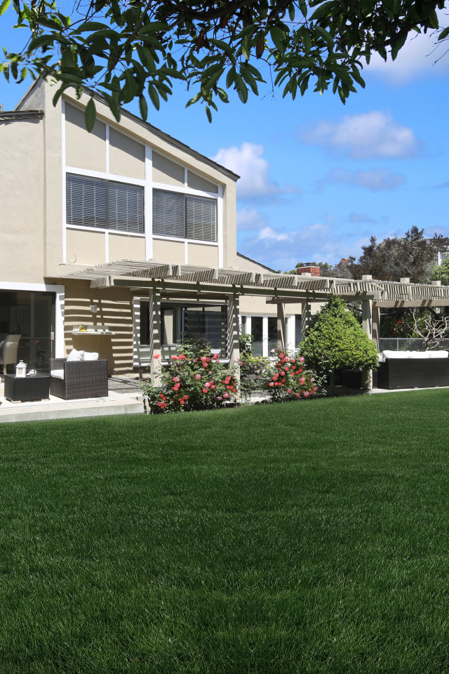 Двухэтажный дом с зеленым газоном 