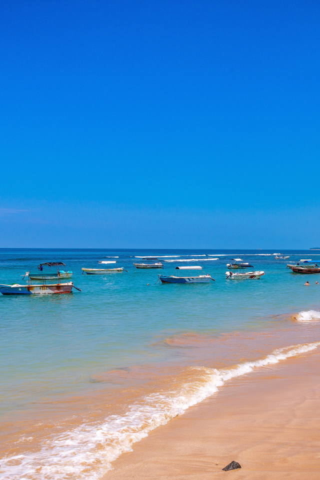Лодки на берегу тропического пляжа на фоне голубого неба 
