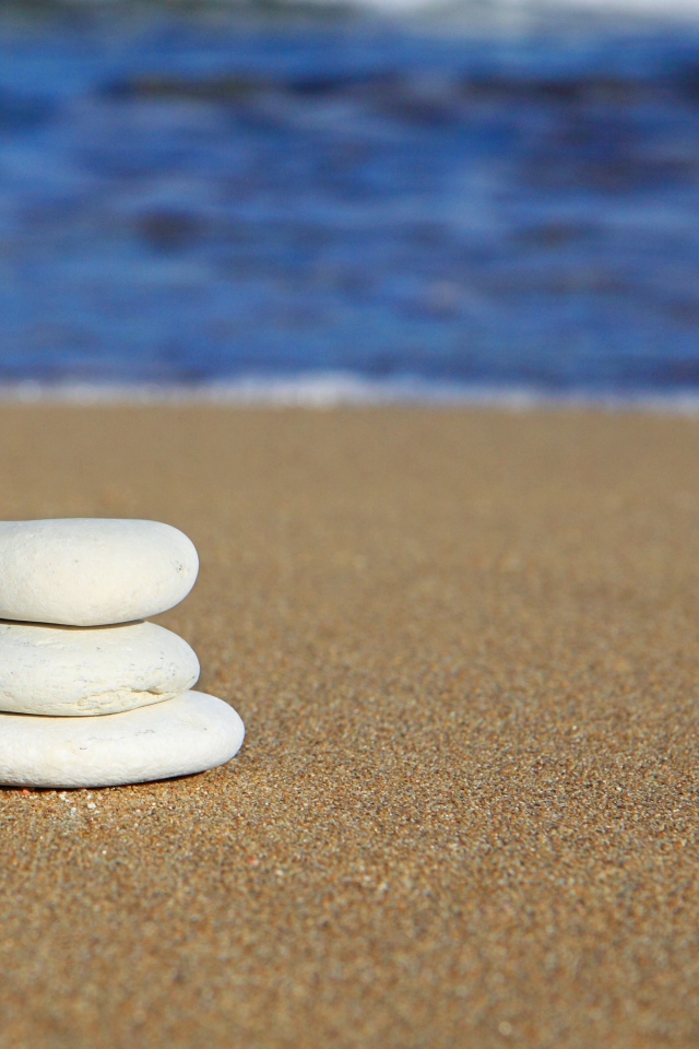 Круглые белые камни на желтом песке 