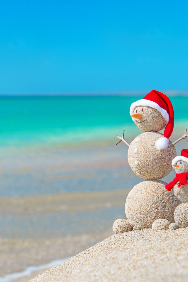 Снеговики из песка на берегу океана 