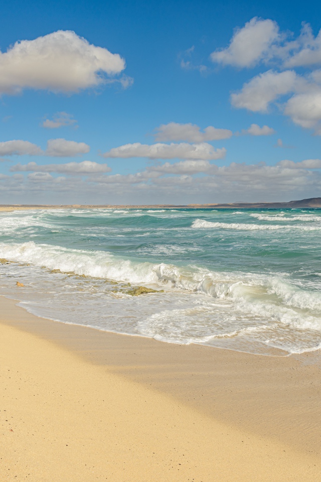 Бушующие морские волны на желтом горячем песке 