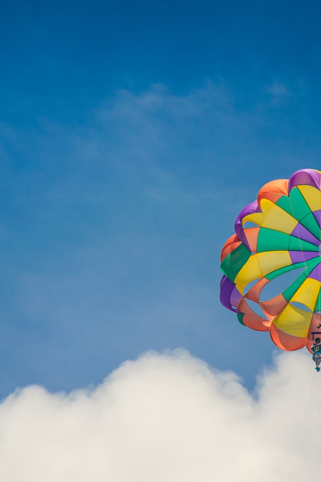 Парашют в голубом небе с белыми облаками