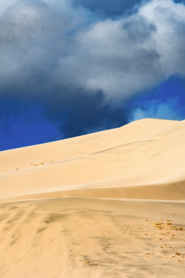 Песчаный бархан под голубым небом