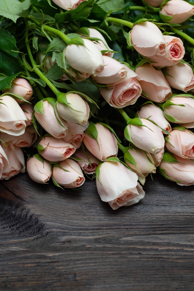 Большой букет розовых роз на деревянном столе 